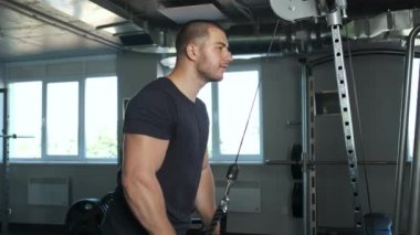 Genç pompalı atlet spor salonunda başka bir pazı egzersizi yapıyor yarışmaya hazırlanmak için.