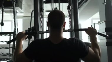 Genç sağlıklı bir atlet yarışmalara hazırlanıyor. Antrenmanlar omuz ve kollarda. Arkadan portre çerçevesi