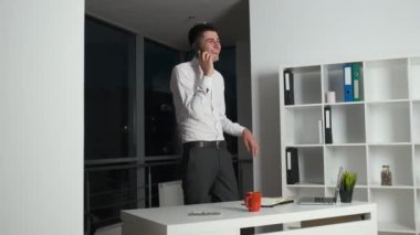 Genç avukat geceye kadar işe geç kalmıştı ve panoramik pencerenin yanında ofisin etrafında dolanıp müşteriyle telefonda konuşuyordu.