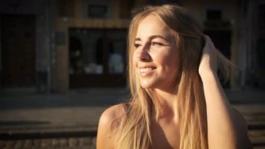 Güzel sarışın, beyaz tenli, samimi bir gülüşü ve güzel, uzun bir elbisesi var. Sabah kentinde kasıla kasıla yürüyor. Kameranın önünde poz vermek. Model