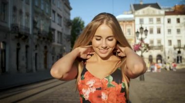 Güzel sarışın, beyaz tenli, samimi bir gülüşü ve güzel, uzun bir elbisesi var. Sabah kentinde kasıla kasıla yürüyor. Kameranın önünde poz vermek. Model