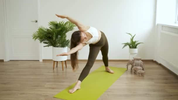 Junge Kaukasierin meditiert zu Hause. Yoga und Fitnesstraining. Stressabbau. Gesundheit — Stockvideo
