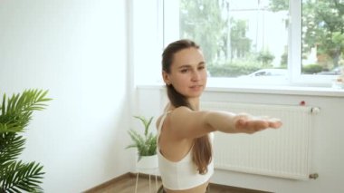 Genç beyaz kadın evde meditasyon yapıyor. Yoga ve fitness egzersizleri. Stres atmak. Sağlık