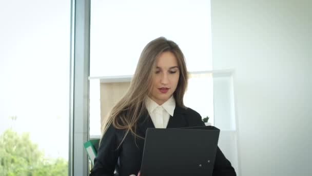 Geschäftsfrau steht mit Ordnern in der Hand im Büro am Panoramafenster. Unterlagen zur Unterzeichnung von Verträgen — Stockvideo