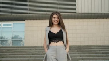 Beyaz görünümlü güzel bir kızın portresi. Gri takım elbiseli samimi bir gülümseme. Ofisin yanındaki merdivenlerden inip öğle yemeği molasına çıkıyor. İş