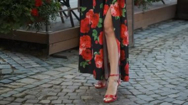 Topuklu giyen ve kameranın önünde poz veren güzel bir kızın bacağı.