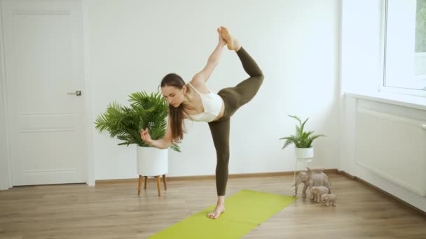 Junge Frau meditiert zu Hause. Professionelle Yoga-Posen im Studio. Gesundheit und Entspannung — Stockvideo