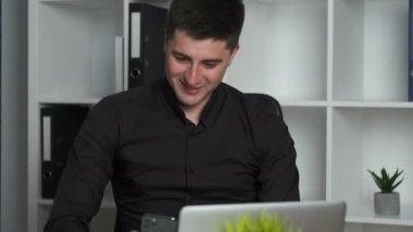 Ofis çalışanı 30 yaşındaki muhasebeci bir deftere yazıyor ve telefonda şirketin sorunlarını çözüyor.