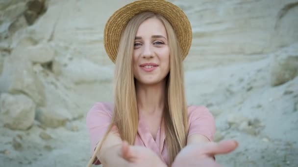 Bella modella bionda in abito rosa e cappello di paglia cammina attraverso il canyon e posa per la fotocamera — Video Stock