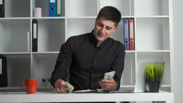 Ένας υπάλληλος γραφείου με κοφτερό μάτι μετράει τα χρήματα και τα γράφει σε ένα σημειωματάριο. Ο λογιστής εκδίδει μισθό — Αρχείο Βίντεο