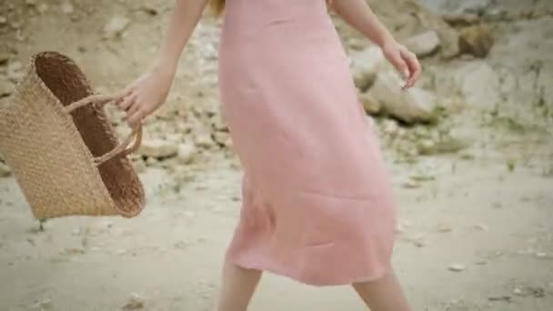 Wanita muda turis dari Caucasian penampilan pirang dalam gaun merah muda dengan tudung dan tas tangan berjalan melalui ngarai dan menikmati keindahan pasir — Stok Video