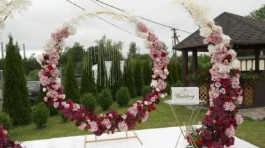 Sokakta kırmızı pembe çiçekli güzel bir düğün dekoru.