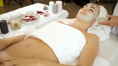 Spa tedavisi için masaya uzanmış bir kadın. Deriyi tazelemek için maske takın. Sağlık ve güzellik