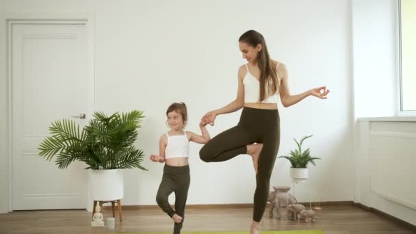 Una madre e sua figlia di 5 anni praticano yoga a casa. Meditazione e salute — Video Stock