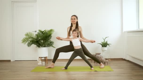 Uma mãe e sua filha de 5 anos praticam ioga em casa. Meditação e saúde — Vídeo de Stock