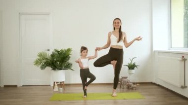 Bir anne ve 5 yaşındaki kızı evde yoga yapıyorlar. Meditasyon ve sağlık