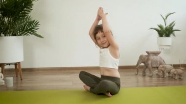 Küçük Kafkasyalı 5 yaşındaki kız evde meditasyon yapıyor. Yoga. Lotus pozu. Sağlık