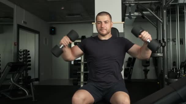 Zdrowy sportowiec o wyglądzie kaukaskim wykonuje kolejne ćwiczenia na siłowni — Wideo stockowe