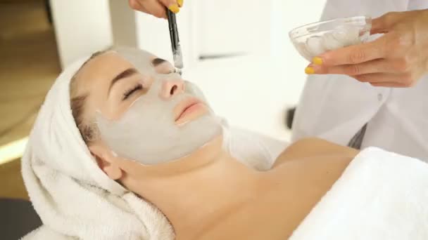 Le patient s'allonge sur la table pour des soins spa. Appliquez un masque pour rajeunir la peau. Santé et beauté — Video