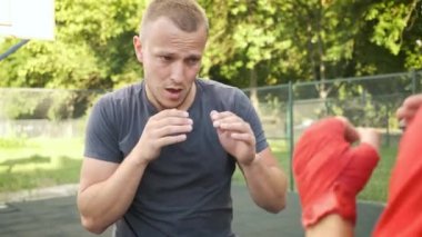 Boks yapıyorum. Beyaz görünümlü genç bir adam antrenmanlarını sokakta yapıyor. Spor ve sağlık