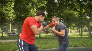 Boks yapıyorum. Beyaz görünümlü genç bir adam antrenmanlarını sokakta yapıyor. Spor ve sağlık