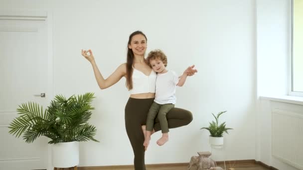 Mamá e hijo pequeño haciendo yoga en casa. Relajación y salud — Vídeo de stock