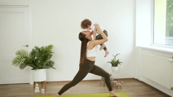 Mamá e hijo pequeño haciendo yoga en casa. Relajación y salud — Vídeos de Stock