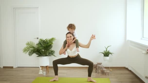 Anya és a kisfia jógáznak otthon. Pihenés és egészség — Stock videók