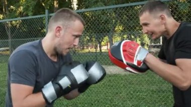 Boks yapıyorum. Beyaz görünümlü genç bir adam antrenmanlarını sokakta yapıyor. Spor ve sağlık