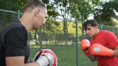 Boks yapıyorum. Beyaz görünümlü genç bir adam antrenmanlarını sokakta yapıyor. Spor ve sağlık