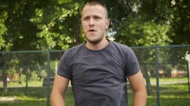 Genç bir adam oyun alanında ısınıyor. Spor ve sağlık