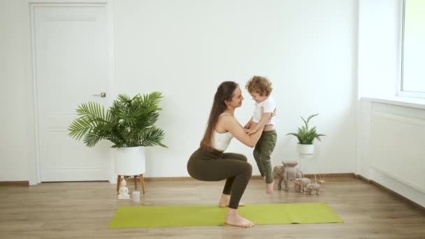 Mamá e hijo pequeño haciendo yoga en casa. Relajación y salud — Vídeos de Stock