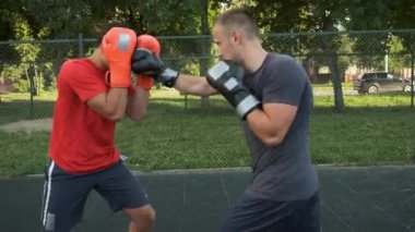 Boks yapıyorum. Beyaz görünümlü genç bir adam antrenmanlarını sokakta yapıyor. Spor ve sağlık