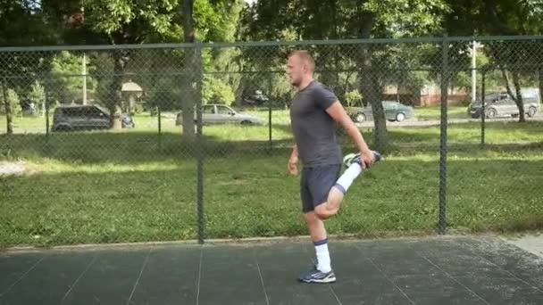 Um jovem aquece no parque infantil. Esportes e saúde — Vídeo de Stock