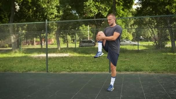 Um jovem aquece no parque infantil. Esportes e saúde — Vídeo de Stock