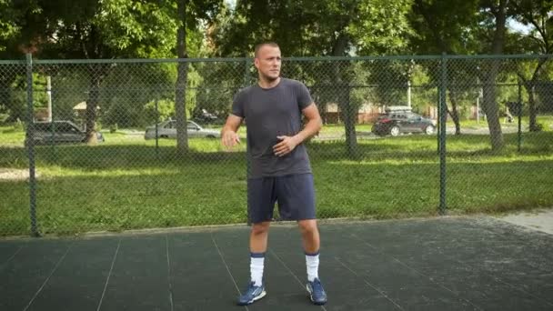 Een jongeman warmt op in de speeltuin. Sport en gezondheid — Stockvideo