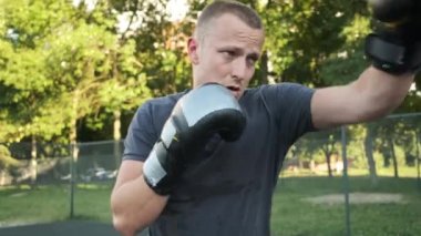 Boks yapıyorum. Beyaz görünümlü genç bir adam antrenmanlarını sokakta yapıyor. Spor ve sağlık