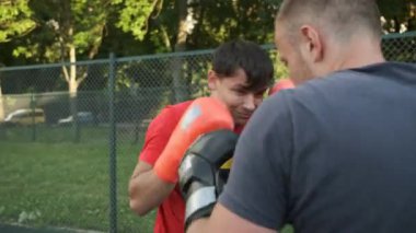 Boks yapıyorum. Beyaz görünümlü genç bir adam antrenmanlarını sokakta yapıyor. Spor ve sağlık