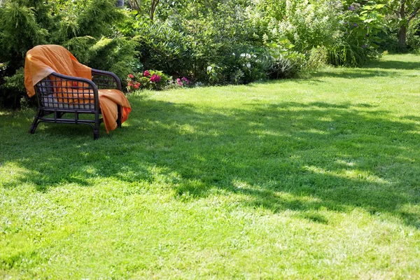 绿色花园中的扶手椅 — 图库照片