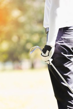 Asya adam golf oynuyor. closeup el erkekler golf dururken sahada oynamak.