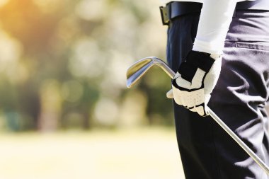 Asya adam golf oynuyor. closeup el erkekler golf dururken sahada oynamak.