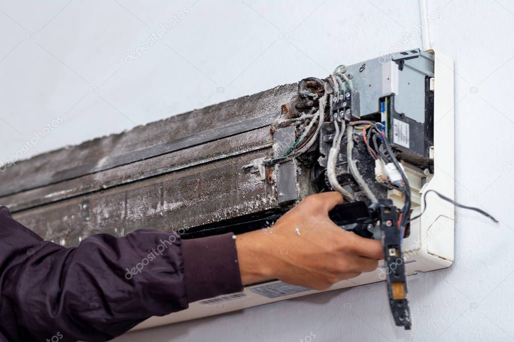 Men worker cleaning electrician air conditioner dirty in home