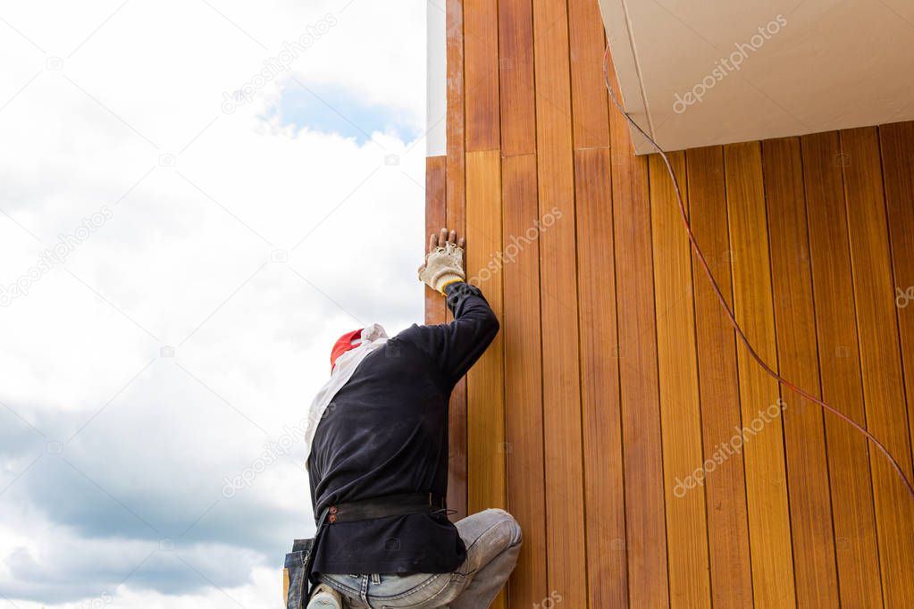 Men build siding Fiber Cement Board on wall exterior