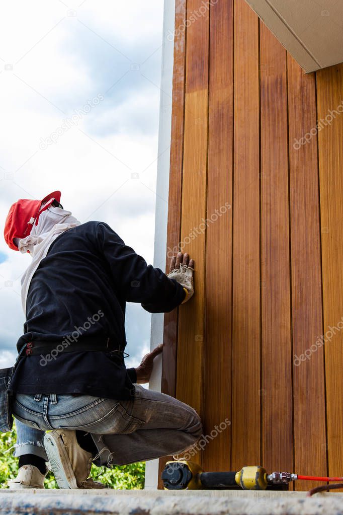 Men build siding Fiber Cement Board on wall exterior