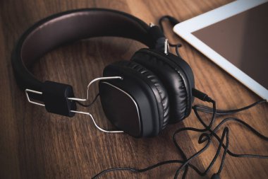 Akıllı telefon ve kulaklık için ahşap arka plan üzerinde müzik dinlemek