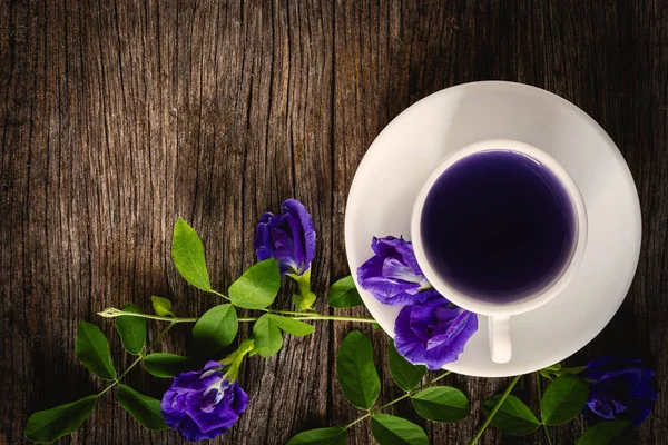 Sağlıklı su bezelye çiçek suyu eski ahşap arka plan üzerine yerleştirilen.