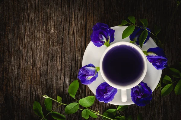 Sağlıklı su bezelye çiçek suyu eski ahşap arka plan üzerine yerleştirilen.