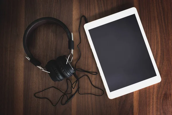 Akıllı telefon ve kulaklık için ahşap arka plan üzerinde müzik dinlemek