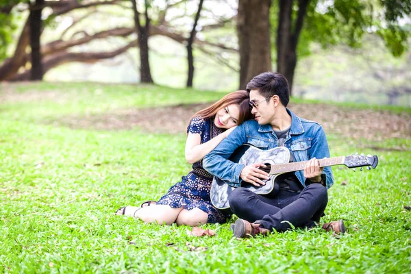 Asijský Pár Lásce Hraje Kytara Akustická Píseň Sedí Trávě Parku — Stock fotografie