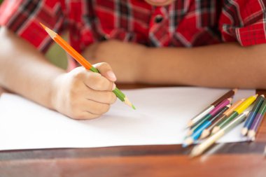 Asyalı küçük çocuk beyaz kağıda yazı renk kalem kullanın